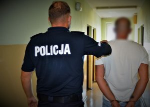 policjant doprowadza zatrzymanego