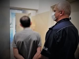 policjant doprowadza zatrzymanego