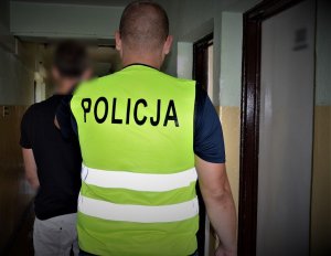 policjanci doprowadzają zatrzymanego