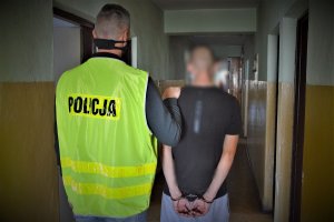 policjant doprowadza zatrzymanego