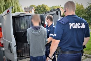 policjanci doprowadzają zatrzymanego