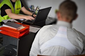 policjantka przesłuchuje zatrzymanego