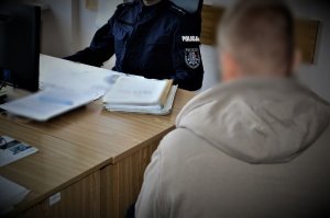 policjant przesłuchuje zatrzymanego