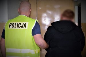 policjanci doprowadzają zatrzymanego