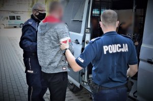 policjanci doprowadzają zatrzymanego