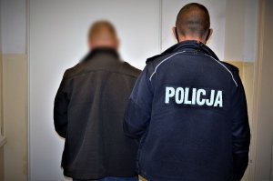 policjant doprowadza zatrzymanego
