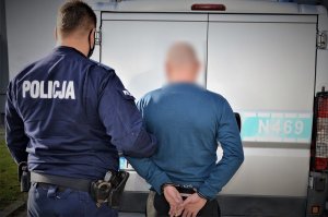 policjanci doprowadzają zatrzymanego