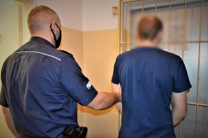 policjanci doprowadzają zatrzymanego
