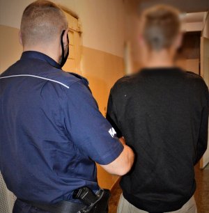 policjanci doprowadzają zatrzymanego