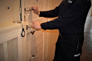 Policjant otwierający cele