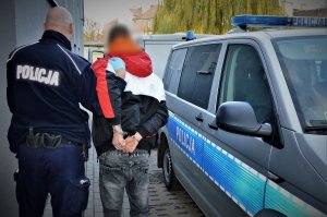 policjant doprowadza zatrzymanego