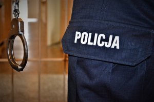 policjant trzyma kajdanki