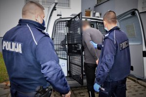 policjanci doprowadzają zatrzymanego