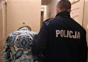 policjant doprowadza zatrzymanego