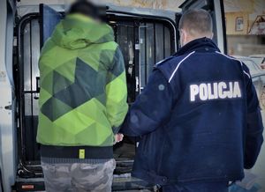 policjanci doprowadzają zatrzymanego