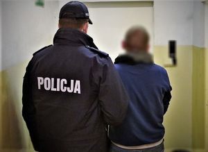 policjant doprowadza zatrzymanego