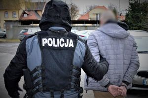 policjant doprowadza zatrzymanego
