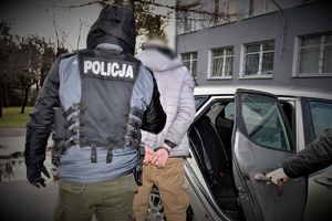 policjant doprowadza zatrzymanego
