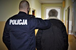 policjant doprowadza zatrzymanego