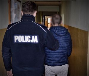 policjant doprowadza zatrzymanego