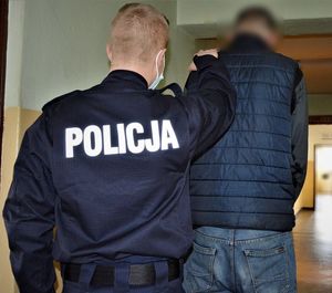 policjant doprowadza zatrzymanego