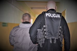 policjant doprowadza zatrzymanego