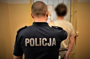 policjant doprowadza zatrzymanego