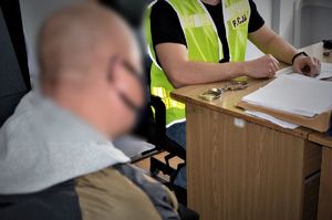 policjant przesłuchuje zatrzymanego