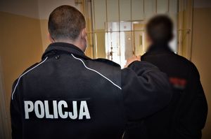 policjant doprowadza zatrzymanego