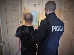 policjant doprowadza zatrzymanych