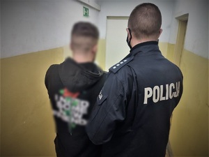 policjant doprowadza zatrzymanych