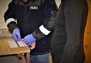 policjanci wykonują czynności z zatrzymanymi