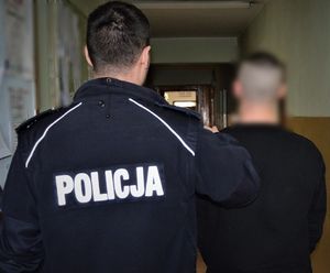 policjant doprowadza zatrzymanego