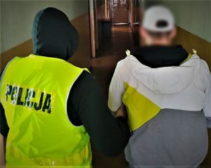 policjant doprowadza zatrzymanego