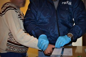 policjant wykonujący czynności z zatrzymanym