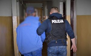policjant prowadzi zatrzymanego