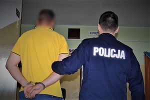 policjant prowadzi zatrzymanego