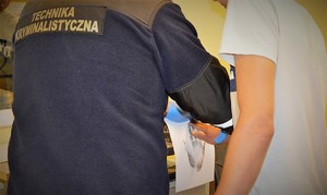 policjant doprowadza zatrzymanego