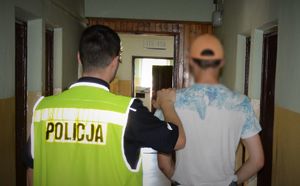 policjant prowadzi zatrzymanego