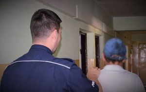 policjant doprowadza zatrzymanego