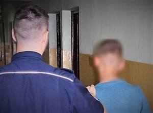 policjant prowadzi zatrzymanego