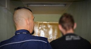 Policjant prowadzi zatrzymanego