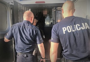 policjant doprowadza zatrzymanego